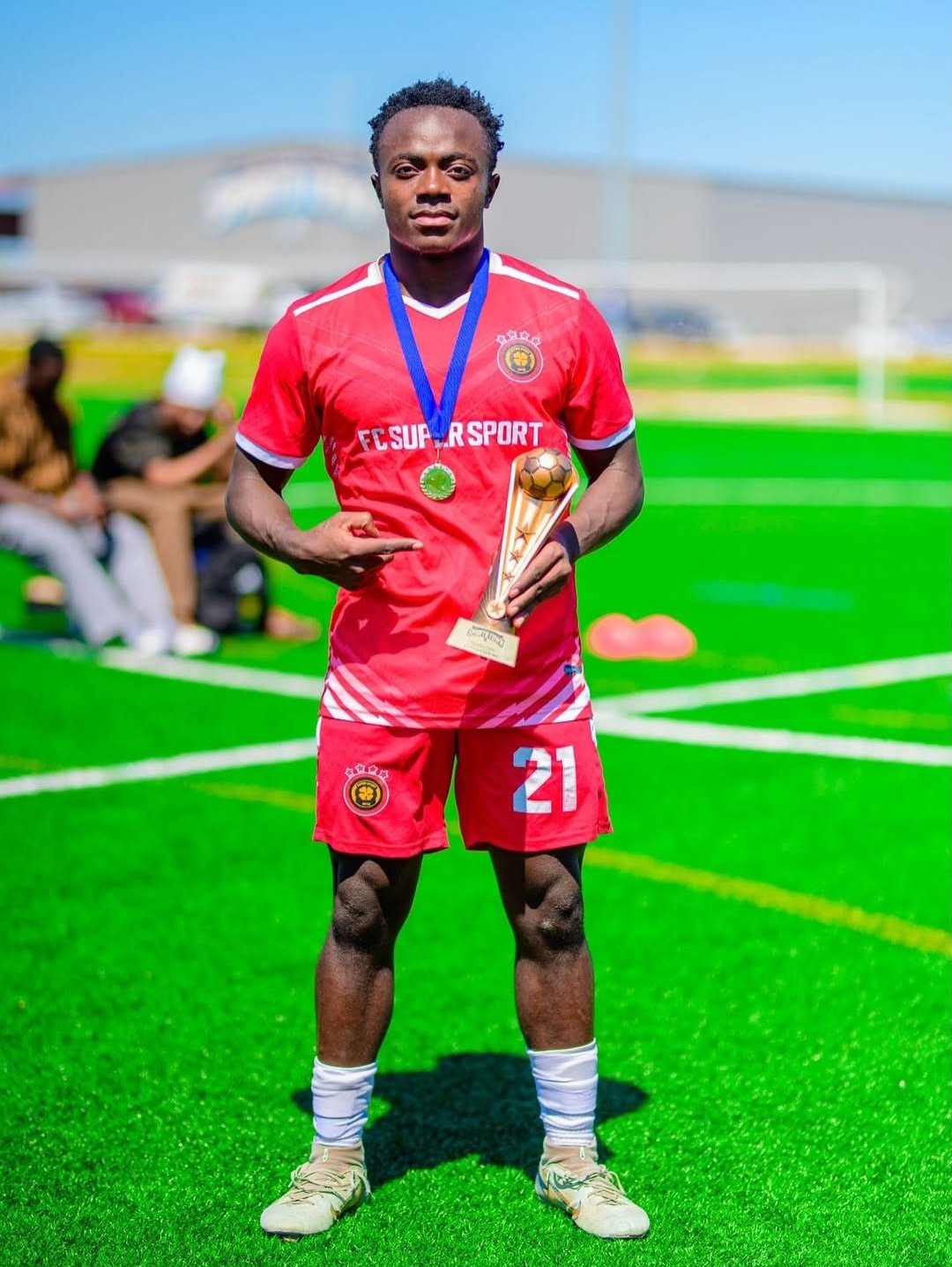 FC Super Sport player number 21 holding the trophy with his medal