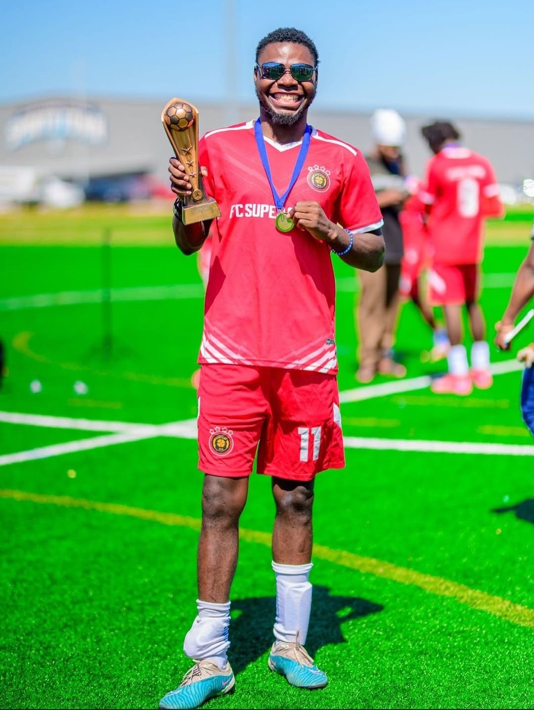 FC Super Sport player number 11 holding the trophy and showing his medal