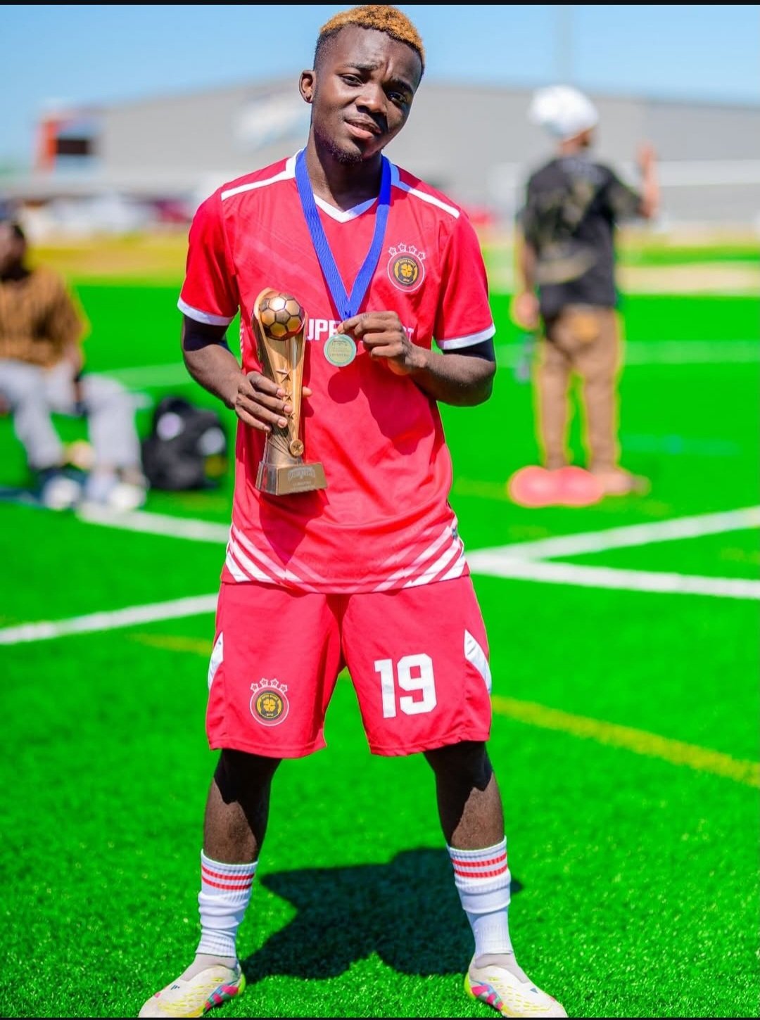 FC Super Sport player number 19 holding the trophy and his medal