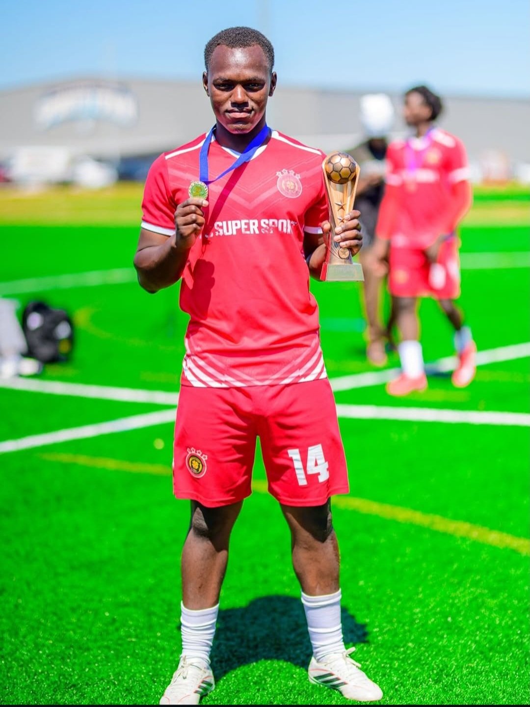 FC Super Sport player number 14 holding the trophy and showing his medal