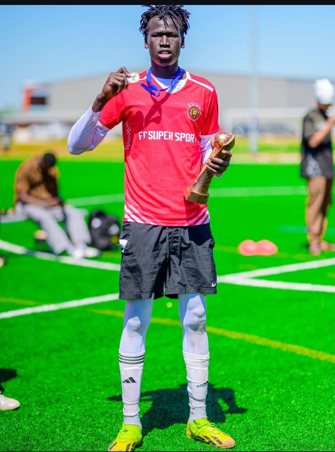 FC Super Sport player holding the trophy and his winner's medal