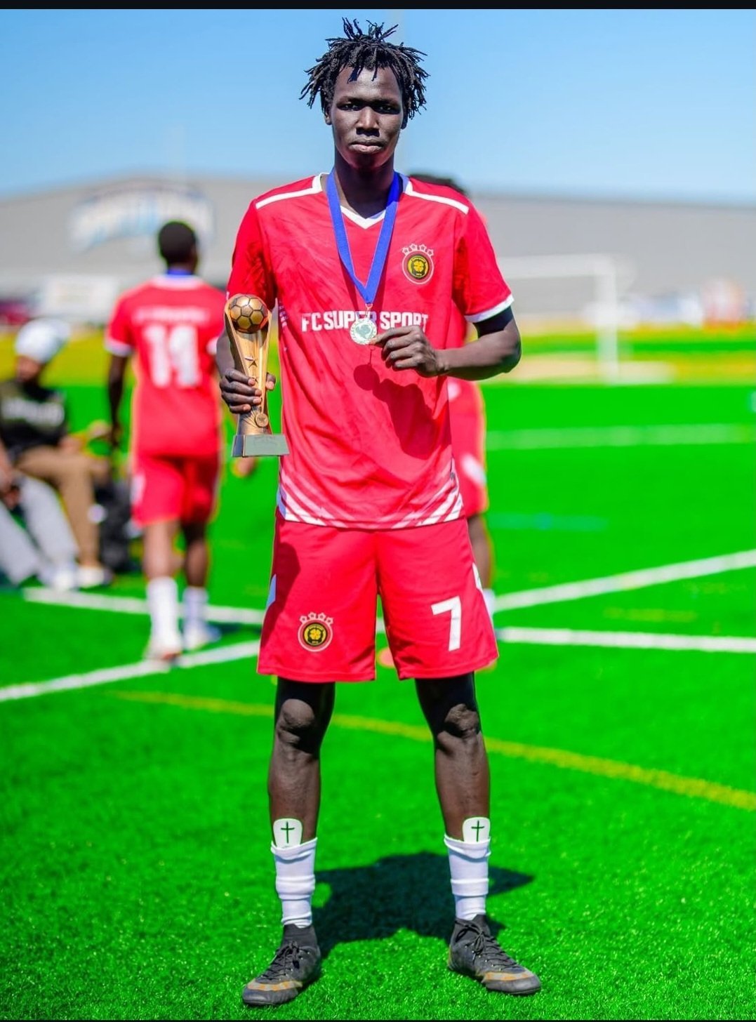 FC Super Sport player number 7 holding the trophy and his winner's medal