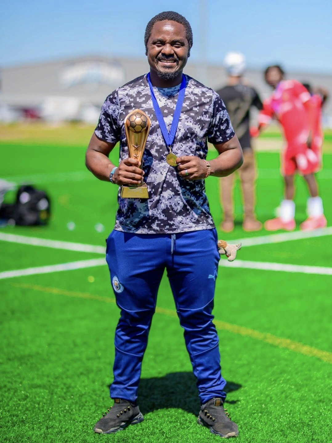 FC Super Sport coach holding the Spring Cup trophy with his winner's medal