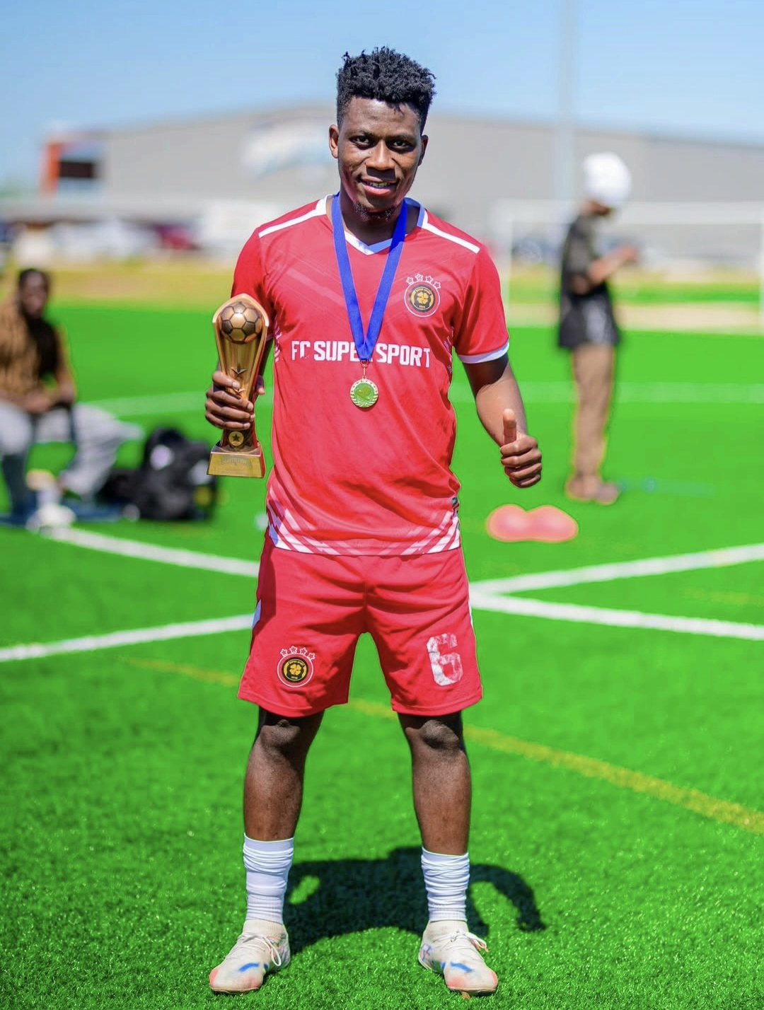 FC Super Sport player number 6 holding the trophy with his medal